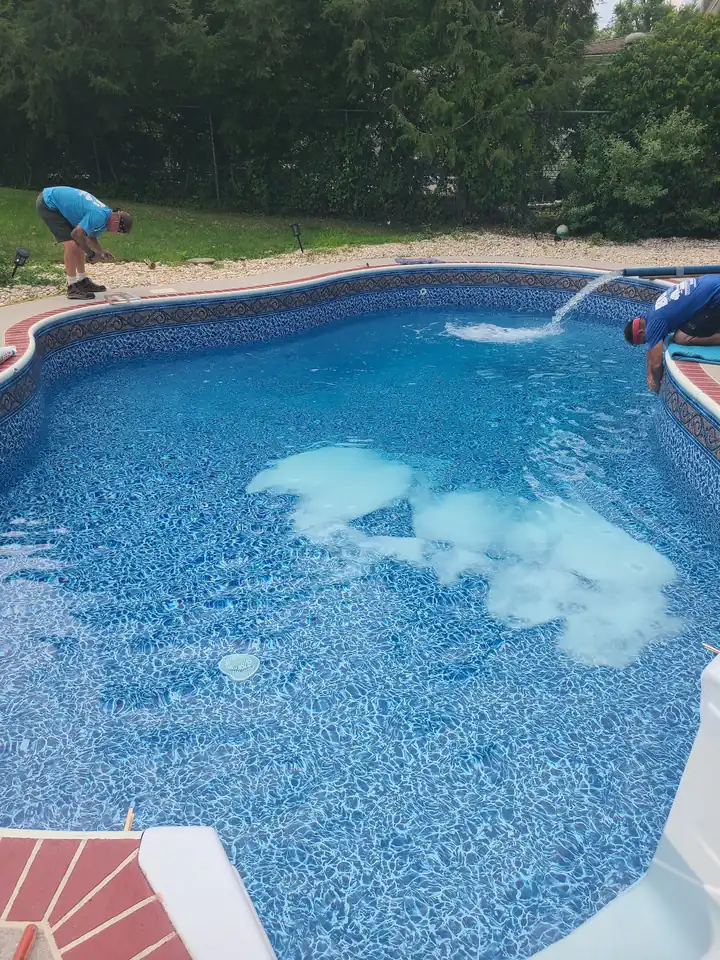 Bob's crew filling a freshly lined pool with water from a hose